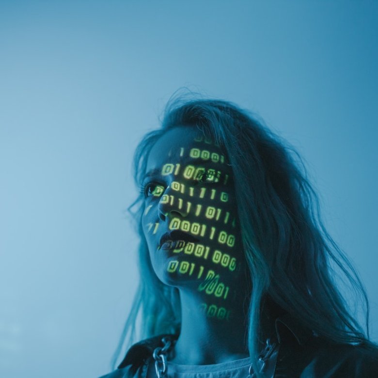 A woman in blue light with yellow numbers projected on her face