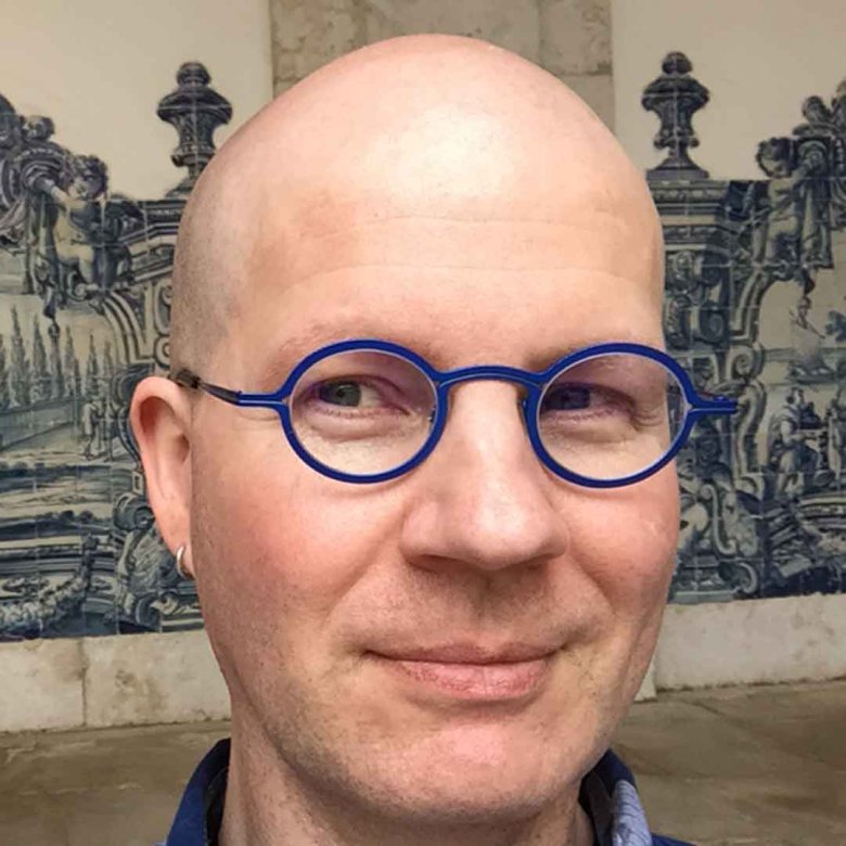 Dr Marshall Moore wearing blue-framed glasses 