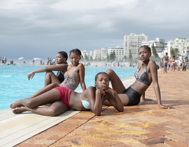 Four girls sat by a poolside in Cape Town, South Africa. 