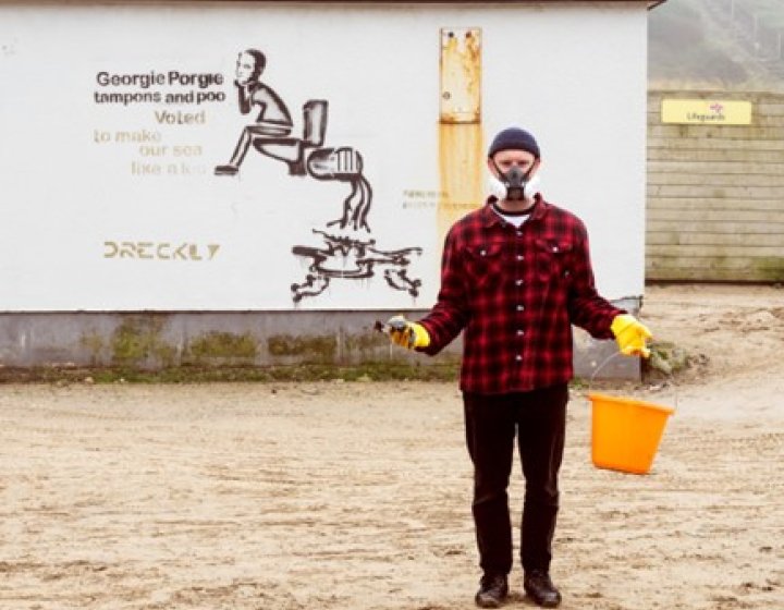Sustainable Product Design graduate Niall Jones wearing mask and carrying a bucket on Porthtowan beach as part of SAS Floater campaign. 