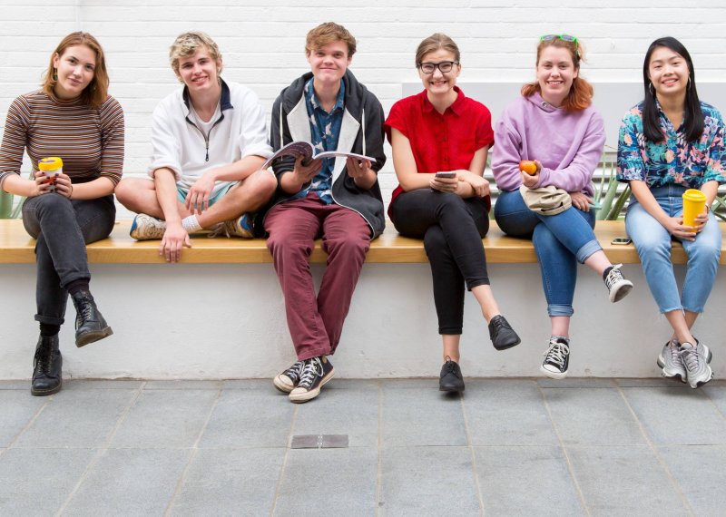 Students sitting on a wall