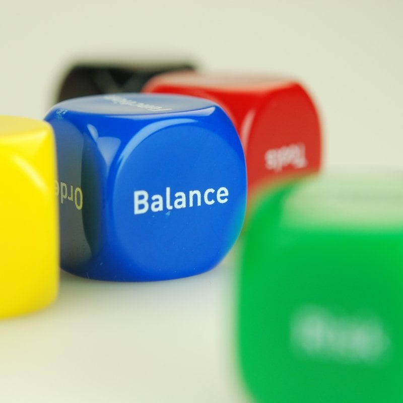 Blue dice with the word 'Balance' and a yellow, red and green dice.