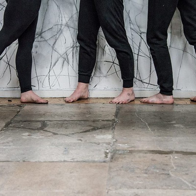 Legs and feet in front of a drawn on wall