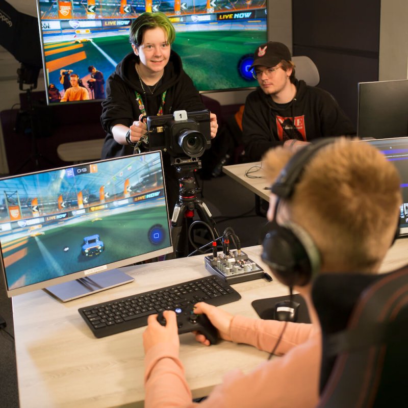 Three Esports students in a studio with screens