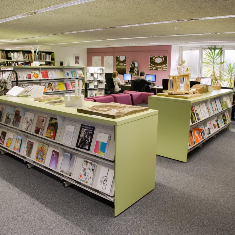 Library interior with magazines and journals on light green shelves
