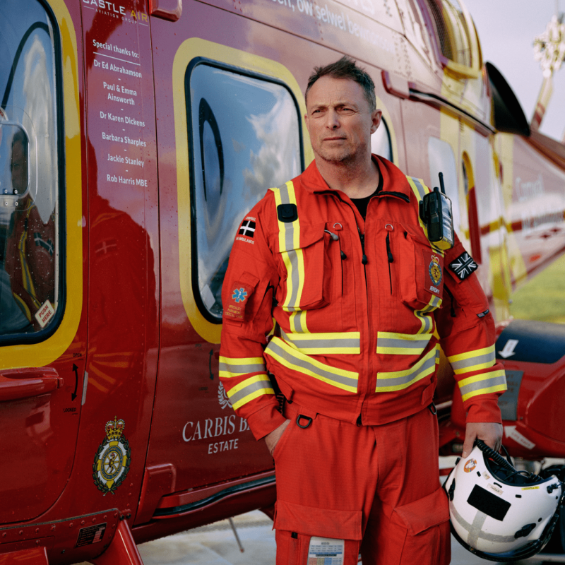 Ambulance helicopter pilot standing next to helicopter. 