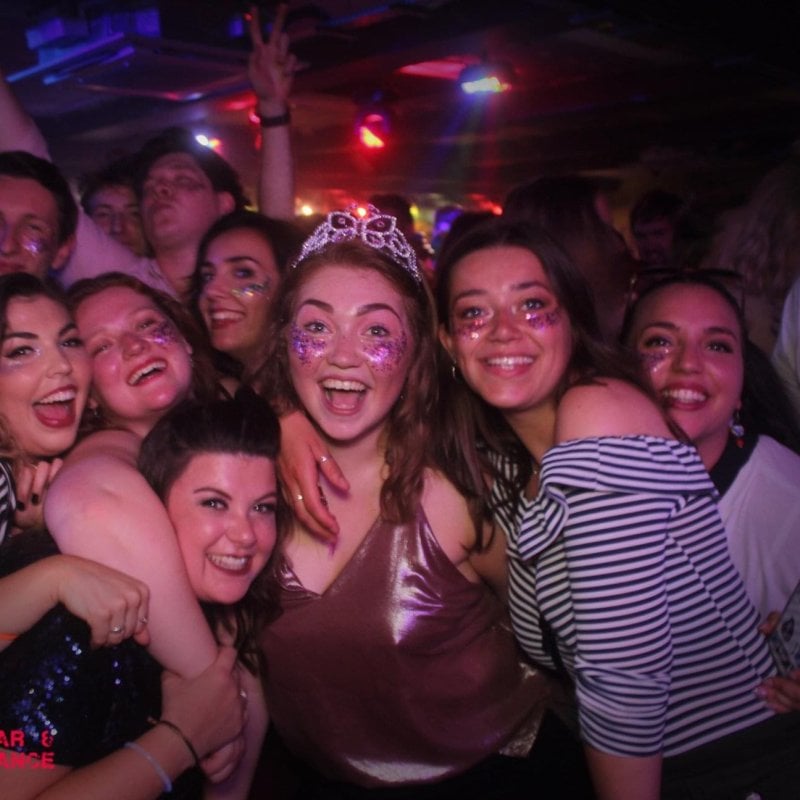 A group of young people posing on a club dance floor