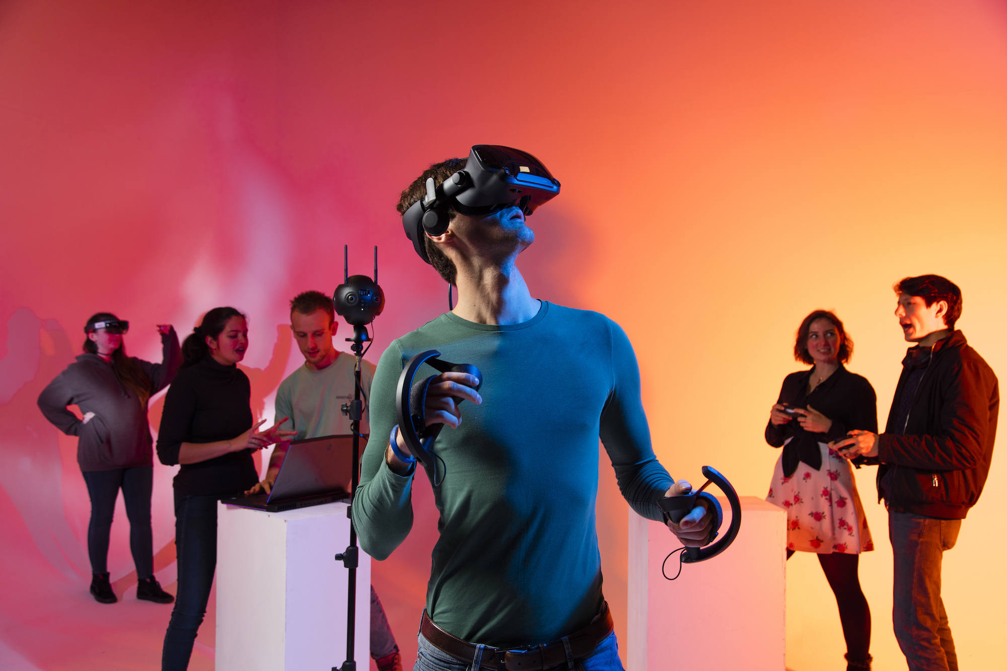 Male student wearing a virtual reality headset with five other students in the background