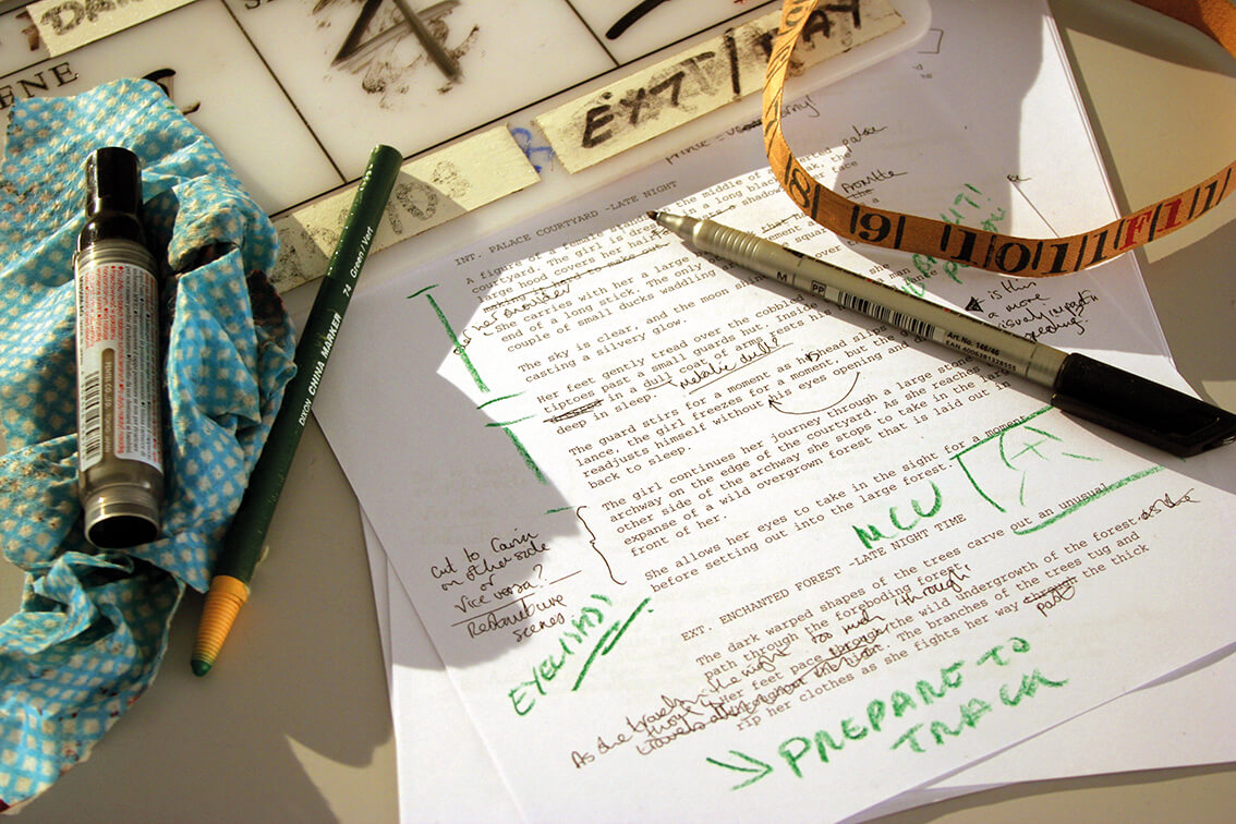 A printed piece of paper with green ink annotations and pens