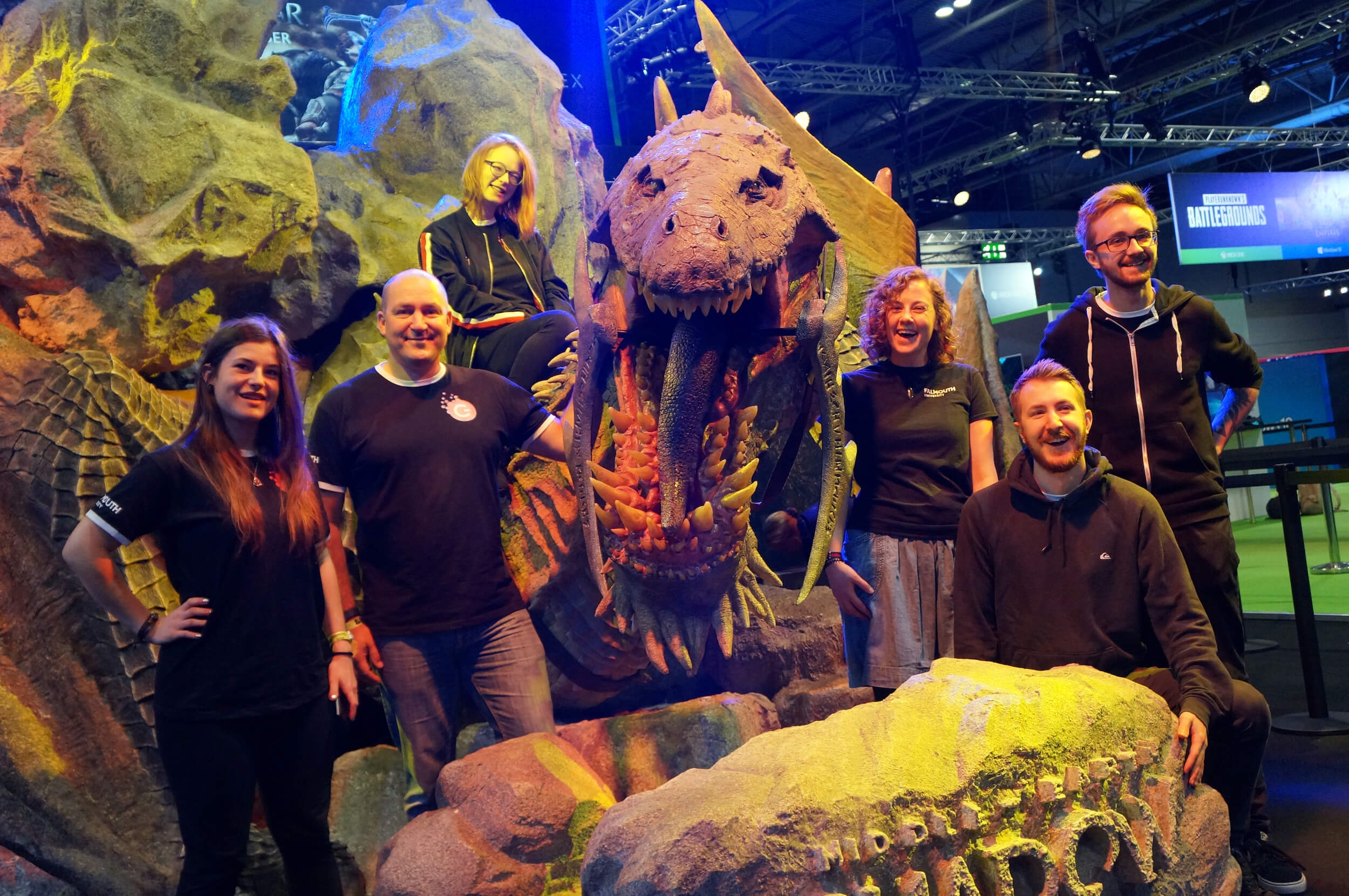 Falmouth University Games Academy students standing in front of a large dinosaur model