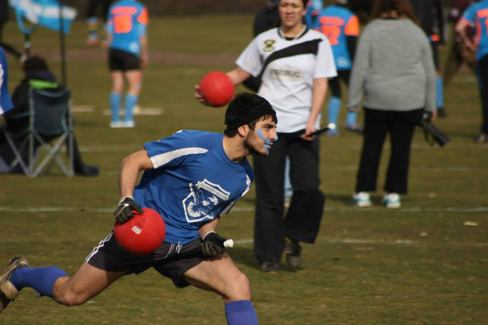 Falmouth University student dressed in blue, playing in the Quidditch society