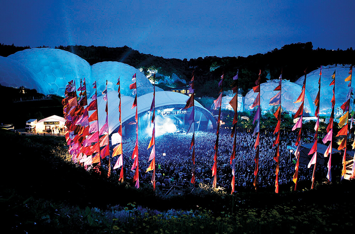 Music festival at the Eden Project with domes and pink flags