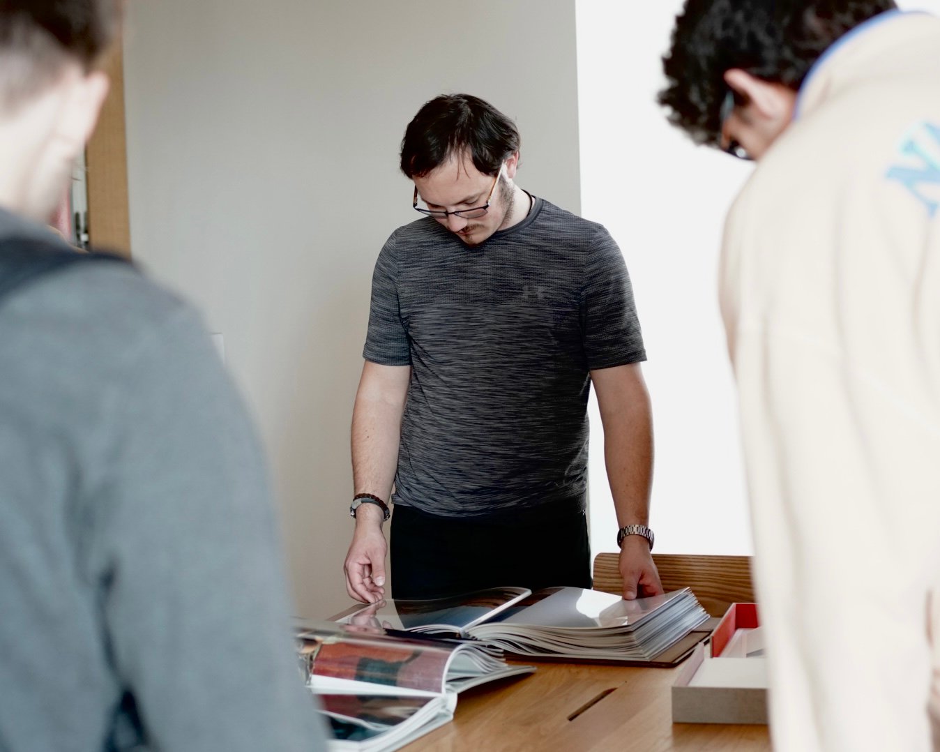 Three people looking at photography portfolios on a table