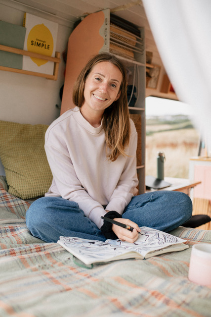 A woman drawing in her van
