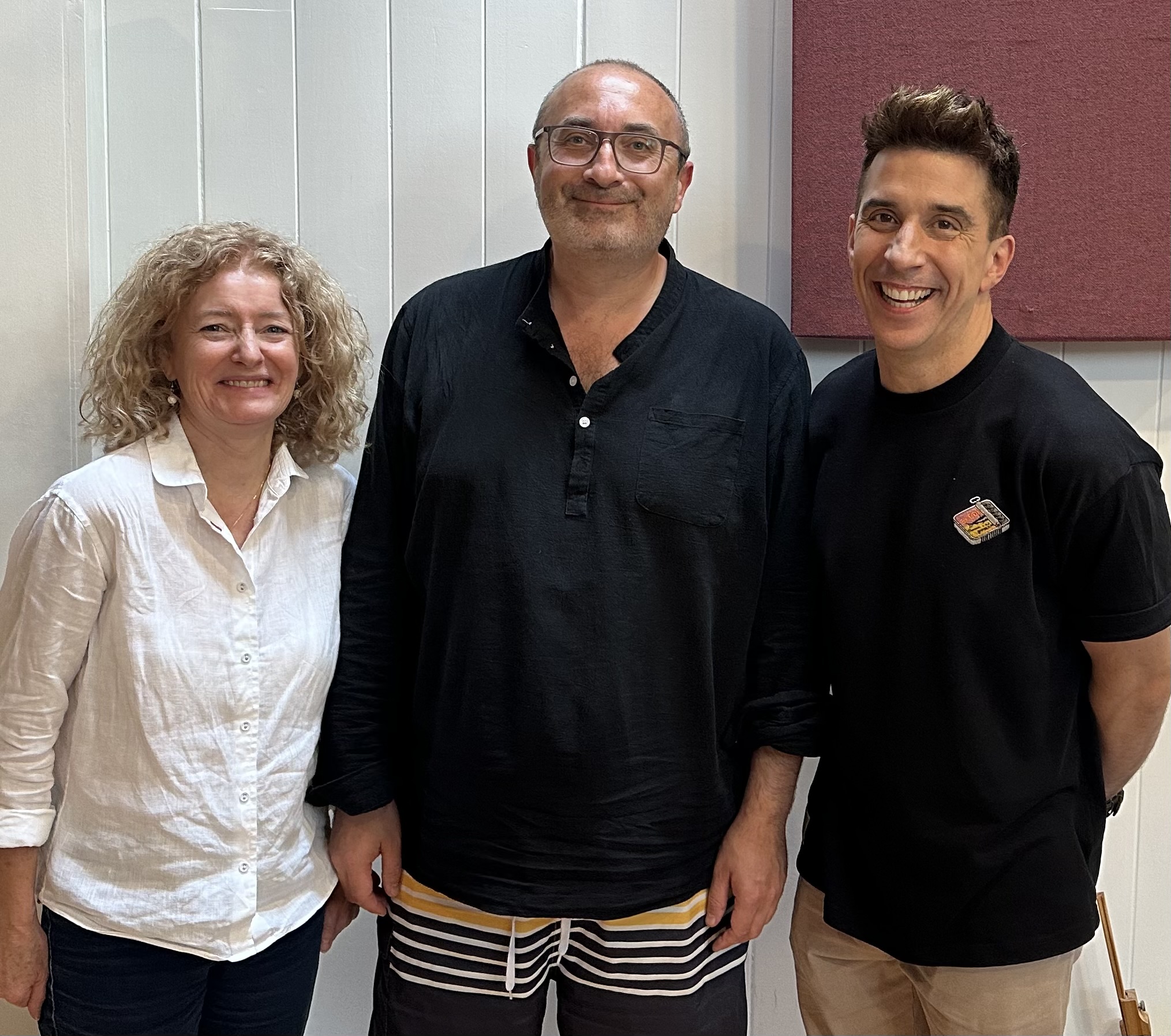 Three people stood smiling into the camera