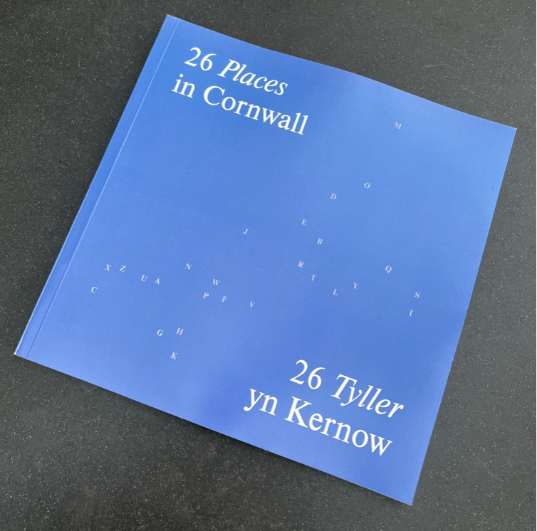 Photo of 26 Cornwall book - light blue cover with A-Z of letters scattered in the shape of Cornwall  in white. Title reads: 26 places Cornwall / 26 Tyller yn Kernow