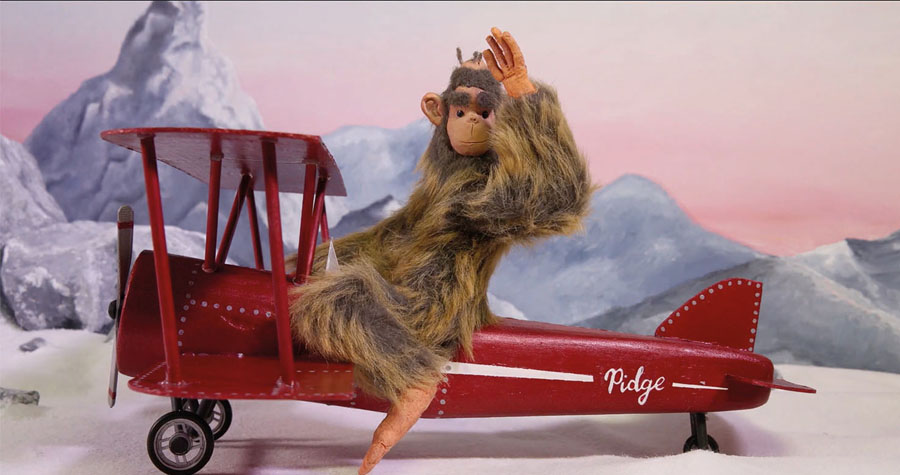 Animation of a monkey sitting on a red plane and waving