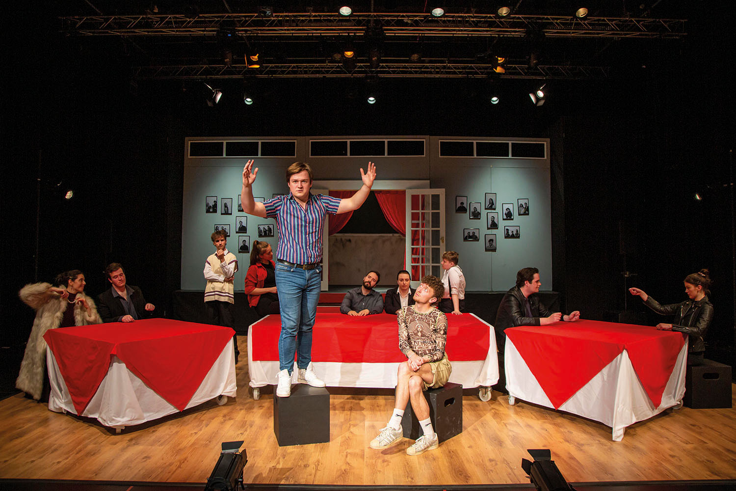 Student stood on a box on stage with arms open