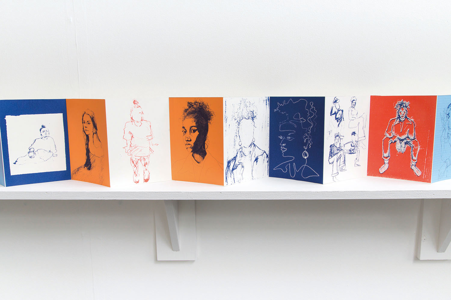 A fold out book of drawings on a shelf
