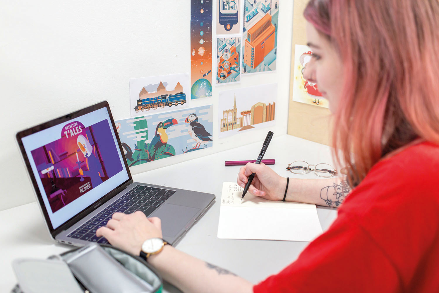 Student looking at laptop and drawing