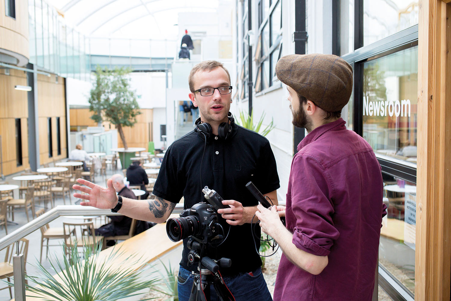 Students chatting and holding recording equipment