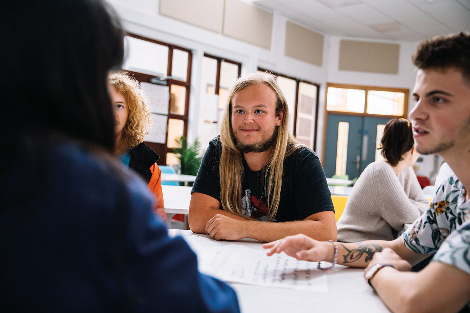 Students sat around a desk chatting