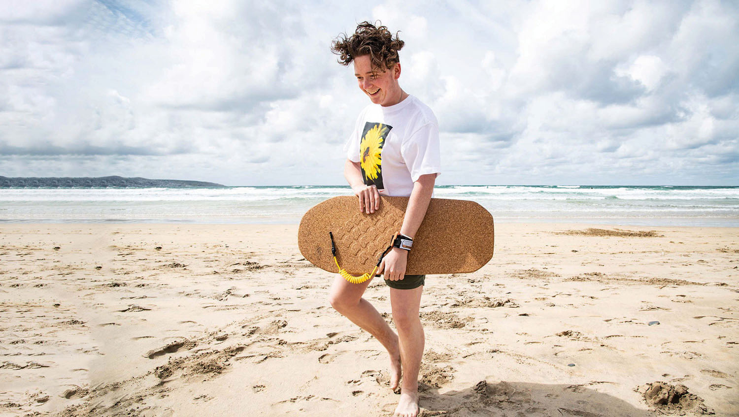 Model carrying cork bodyboard on beach