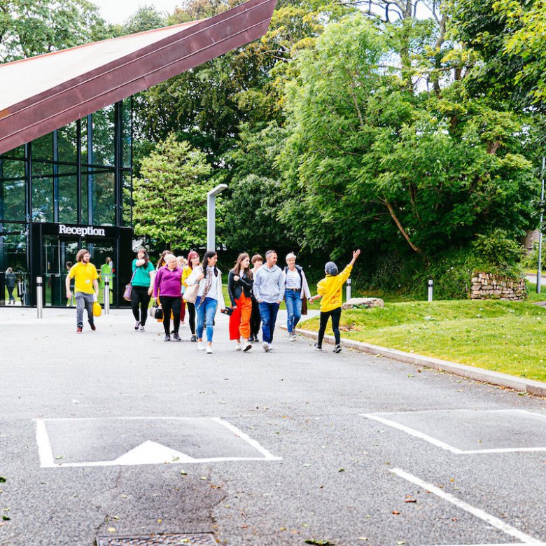 a student showing a group of people around Falmouth University campus at an Open Day
