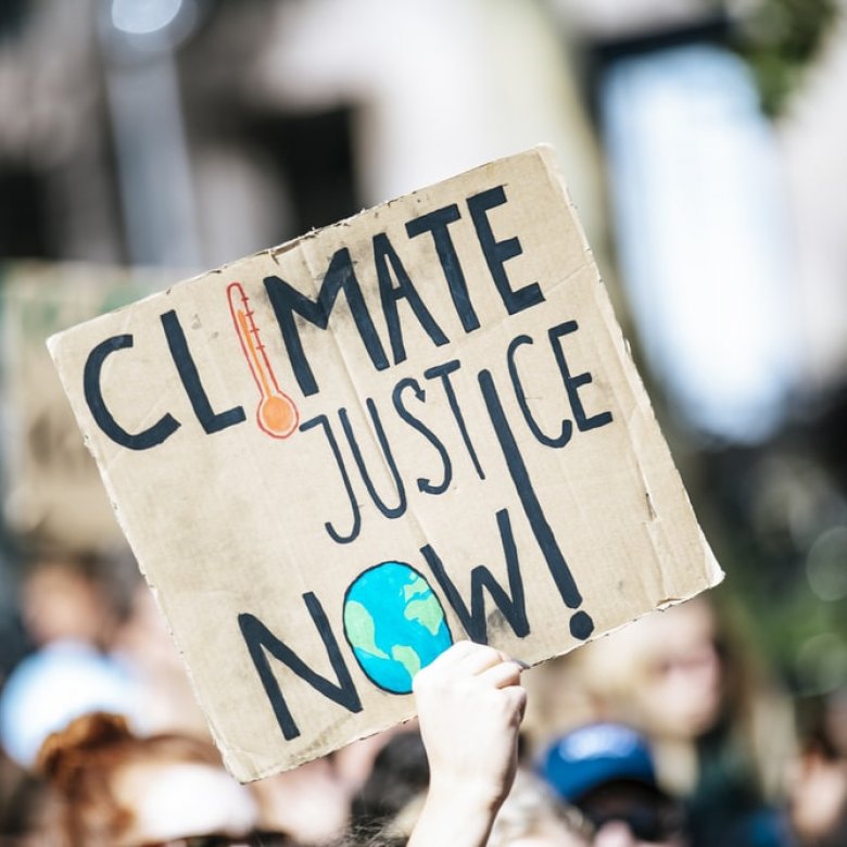 Image of protest placard reads 'Climate Justice Now'