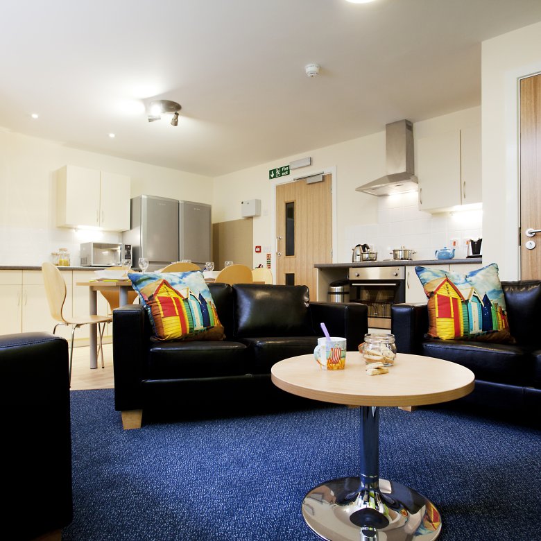 The Sidings' open-plan living area with kitchen and cluster of soft seating 