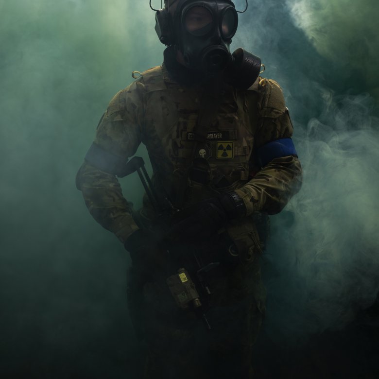 An airsoft player emerging from smoke