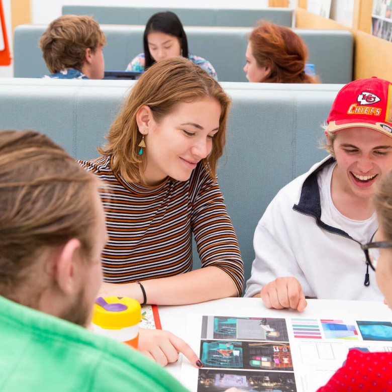 Four Falmouth University students sat around a table looking at a print out