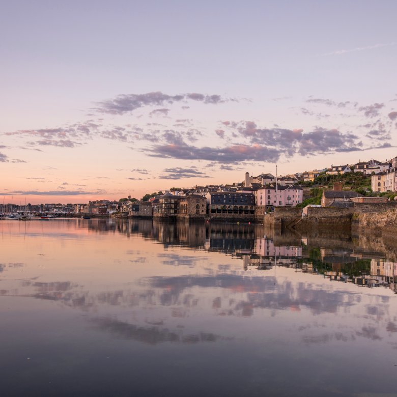 Buildings on the edge of the water with a purple sky