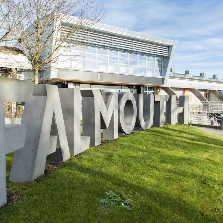 Falmouth University concrete sign in front of glass building