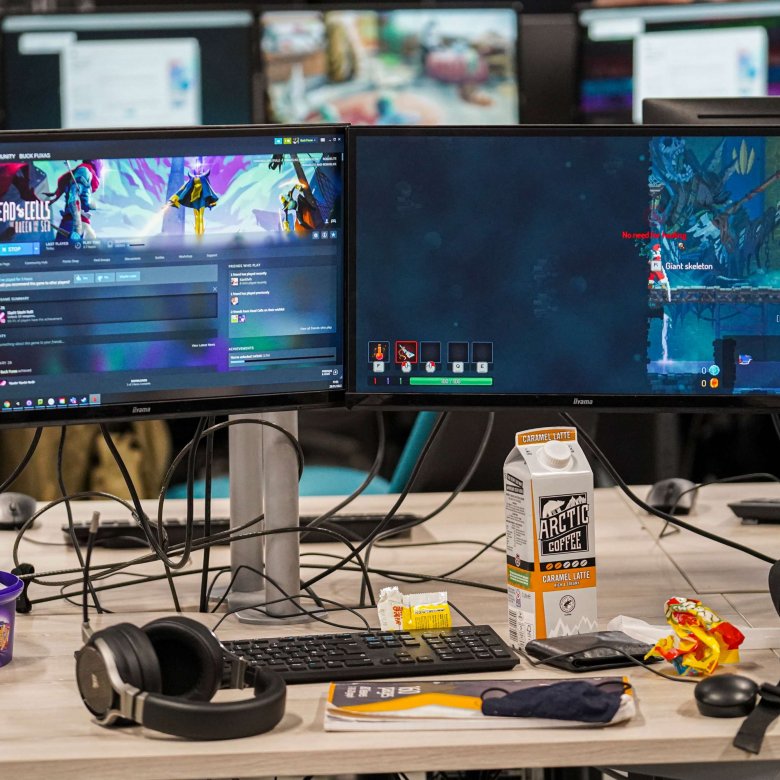 A computer is surrounded by coffee and sweets 