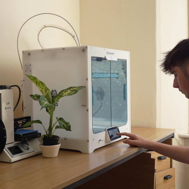 A Falmouth University Sustainable Product Design student with a 3D printer