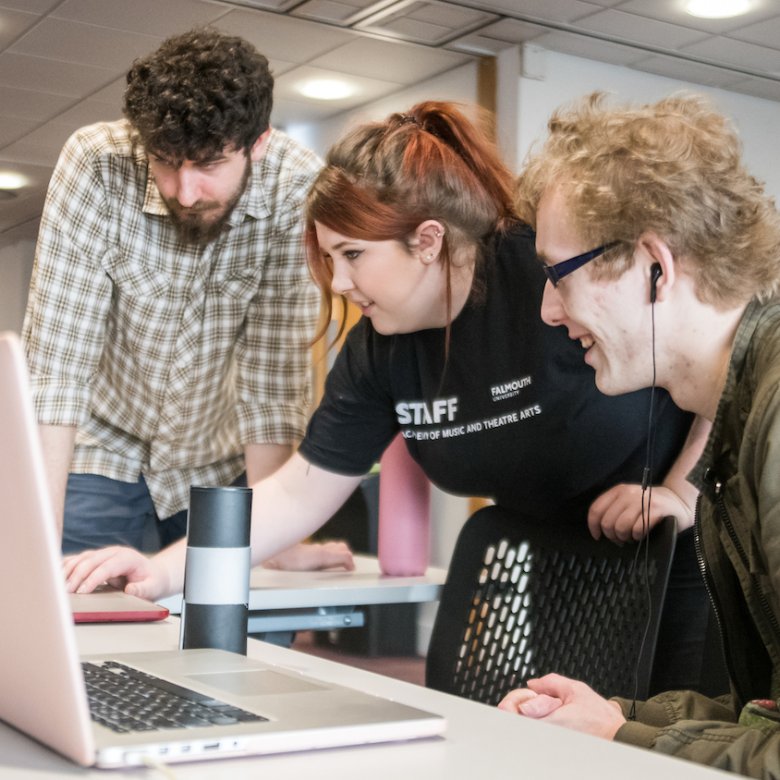 Three students around laptop