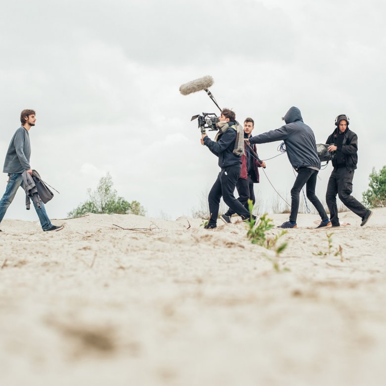 Students man cameras and lighting equipment on the set of Origin