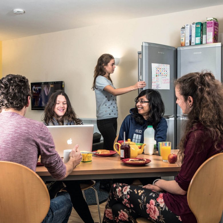 A group of Falmouth University students sat round a table having breakfast in university halls
