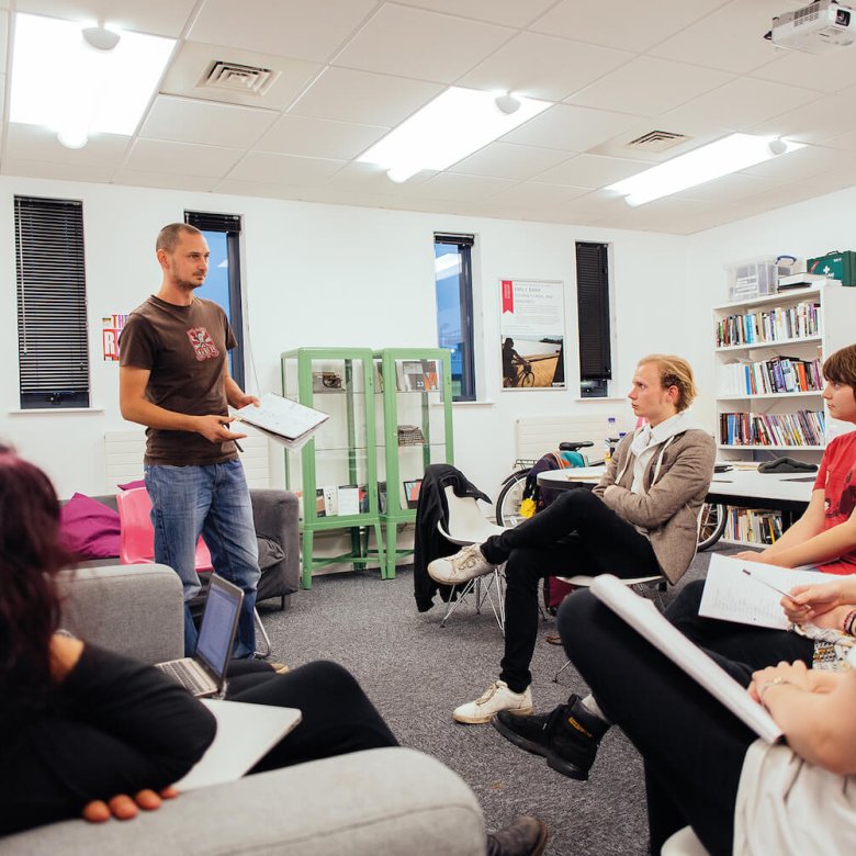 A Falmouth University student stood up presenting to other students in a seminar