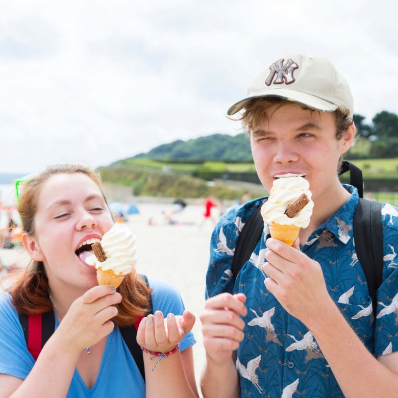 Two Falmouth University students eating ice creams on the beach