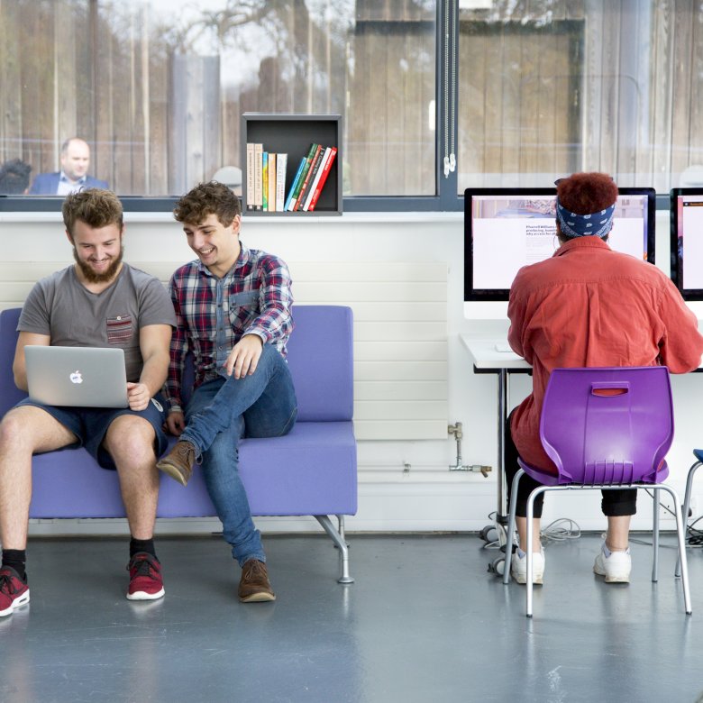 Business students looking at laptop together