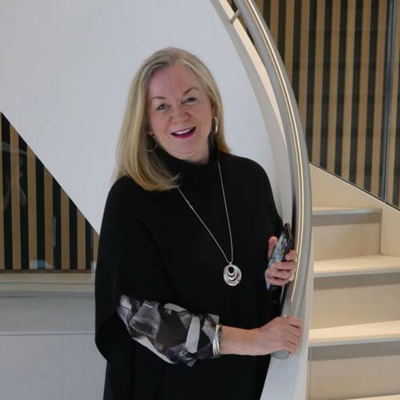 Professor Anne Carlisle in front of a staircase