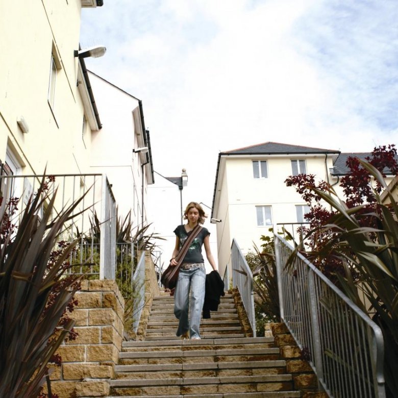 Student walking down steps between buildings.