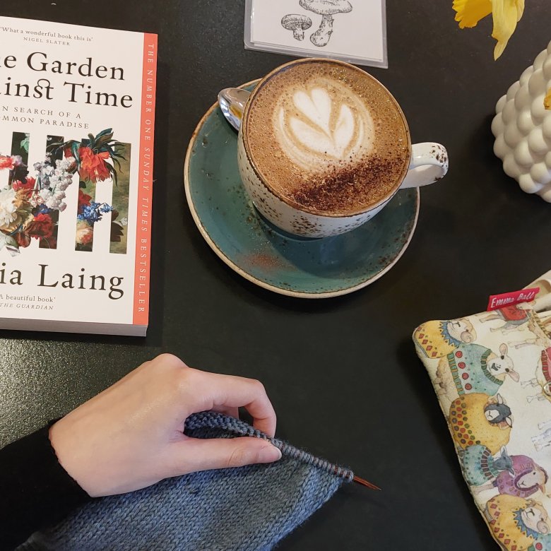 A desk setup with a book and a coffee