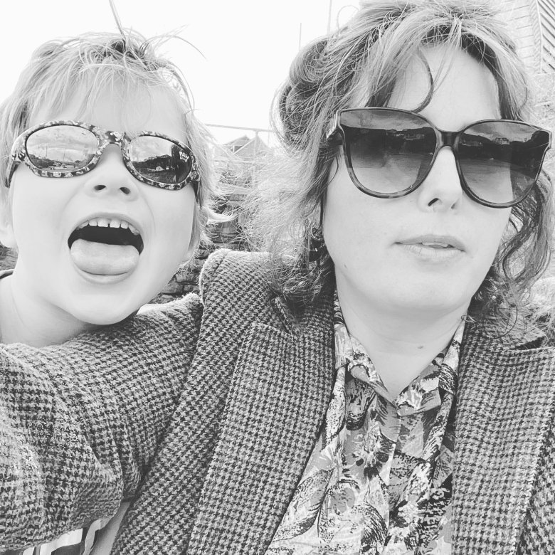 A woman wearing sunglasses next to a small boy