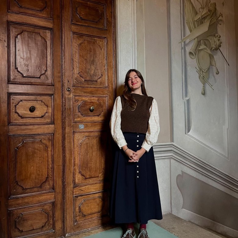 A woman stood in front of a large wooden door
