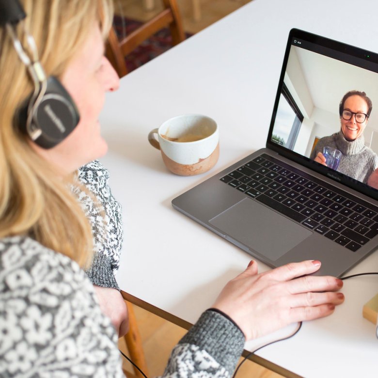 A woman at her laptop talking to a course peer online