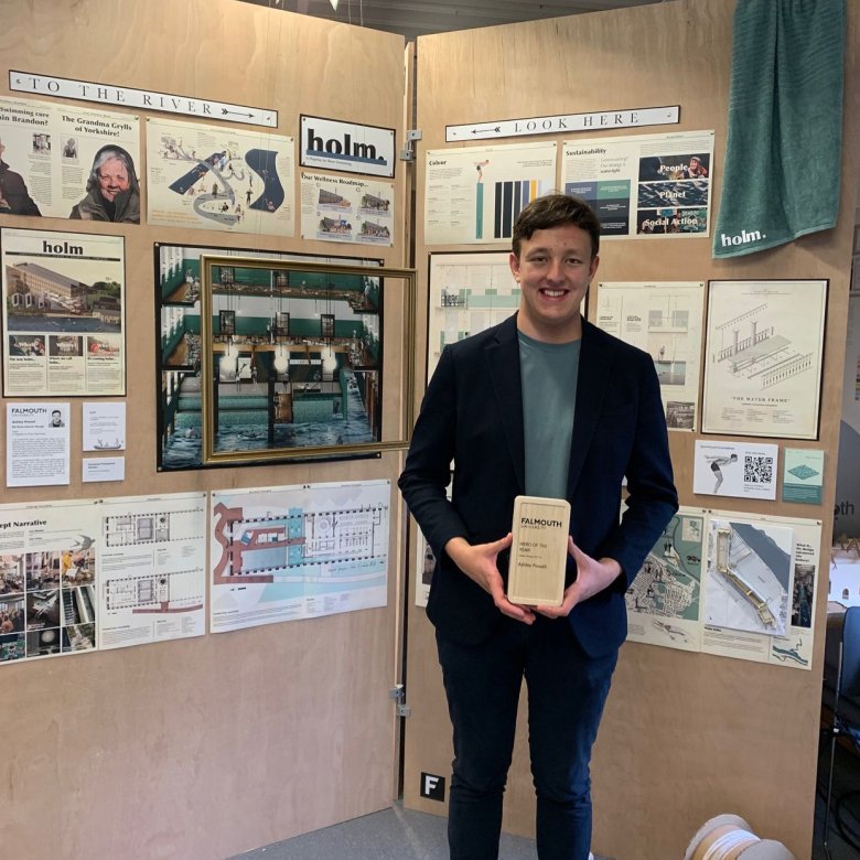 A man stands by a project display at 