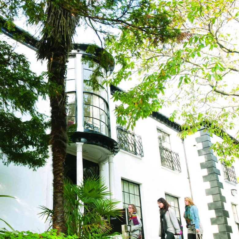 A white building behind greenery